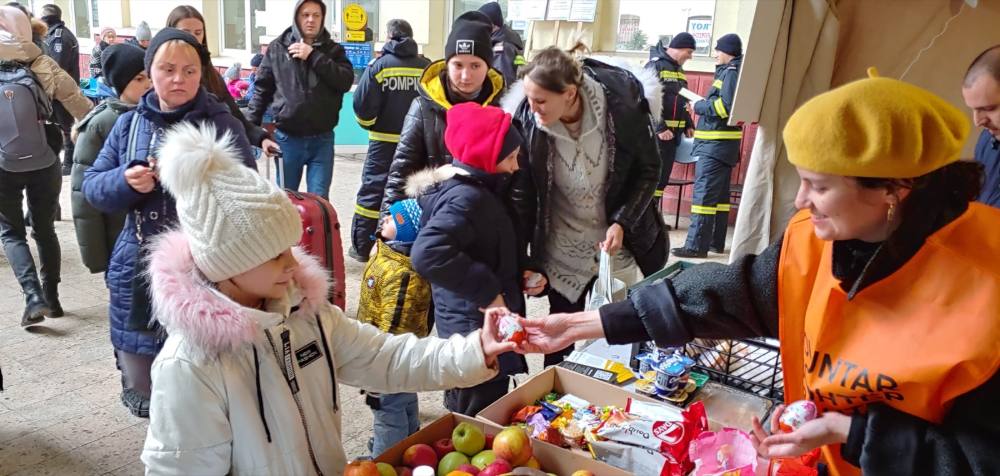 Voluntari care împart mere și pachete refugiaților, la Filaret