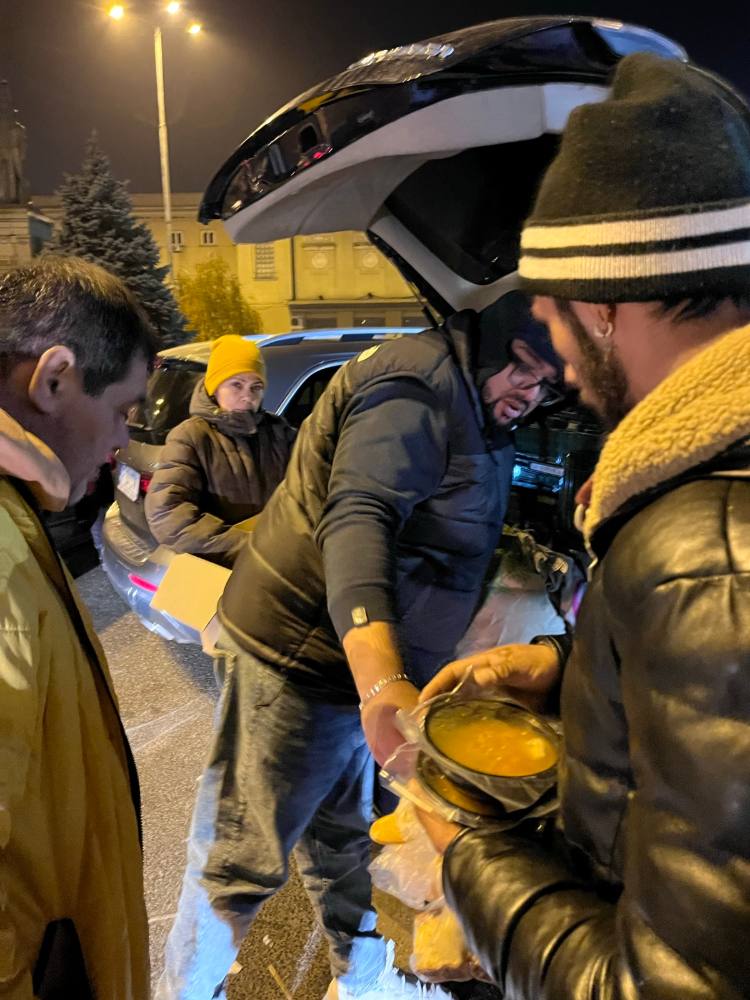 Porții calde date din portbagaj, seara, oamenilor care așteaptă