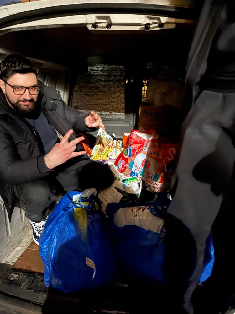Voluntar care încarcă pachete în dubă